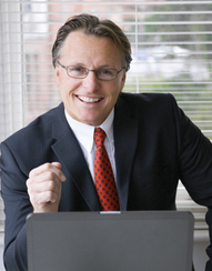 A happy smiling businessman working on laptop.